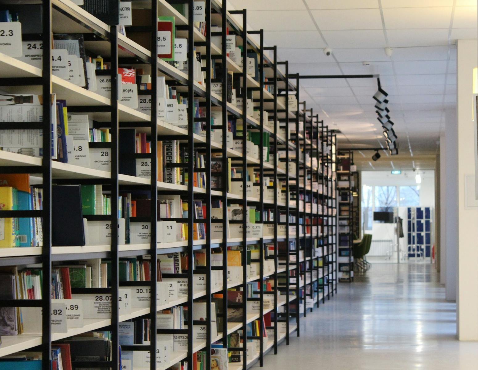 AI Implant Planning: Better Citations, Worse Spatial Sense? A spacious modern library with organized bookshelves and a well-lit aisle, perfect for reading and research.