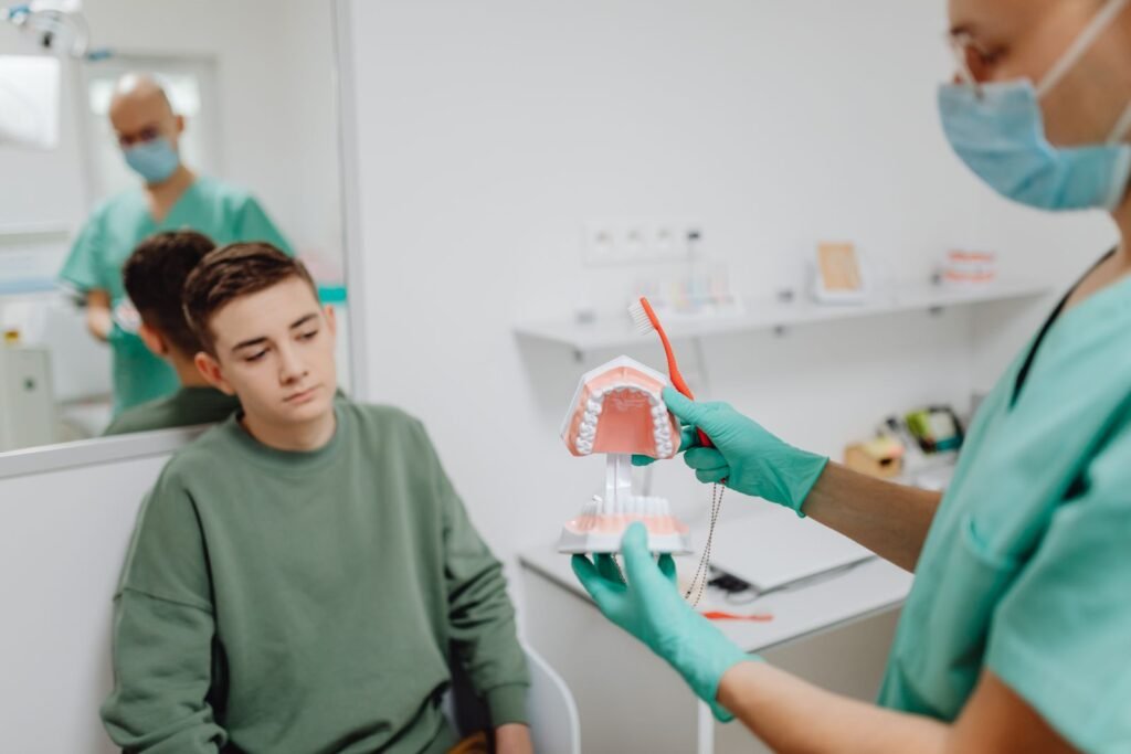AI in Dental Education: Learning Tool or Crutch? Teenager learning dental hygiene from dentist using a dental model.