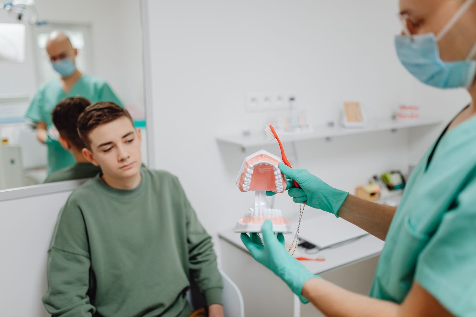 AI in Dental Education: Learning Tool or Crutch? Teenager learning dental hygiene from dentist using a dental model.