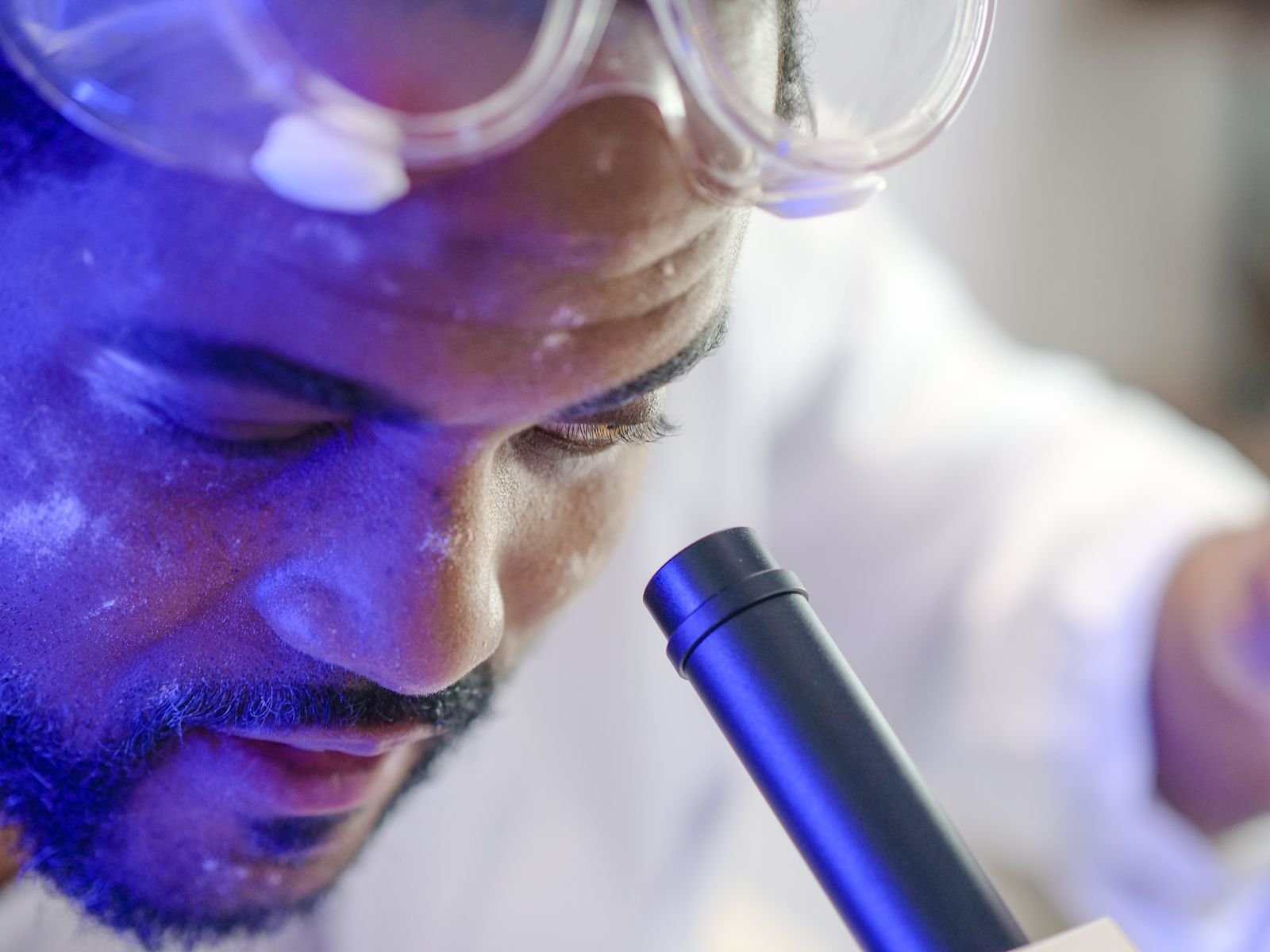 AI Gum Disease Prediction: Forecast or Shaky Guess? Close-up of a scientist using a microscope in a laboratory setting.