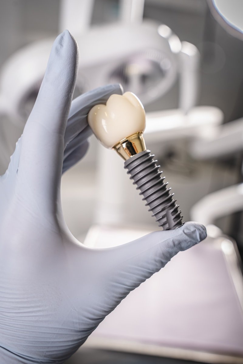 AI Implant Planning: A Surgeon's Blueprint or a Rough Draft? Gloved hand holding a dental implant and crown.